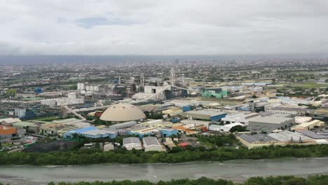 Aerial-drone-pan-shot-capturing-the-large-industrial-area-across-the-river-in-suao-township,-Yilan-city,-Taiwan,-Asia