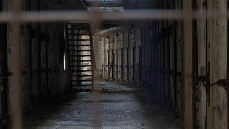 Decrepit-prison-cellblock-seen-through-bars