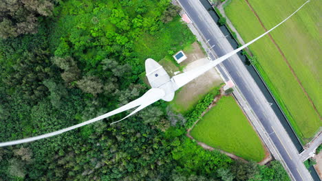 Aerial-top-down-shot-of-rotating-wind-turbine-in-rural-landscape-in-China-during-daytime-