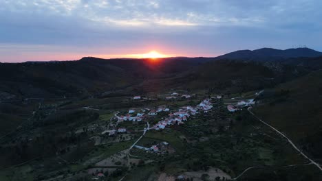 Drohnenansicht,-Die-Während-Des-Sonnenuntergangs-Durch-Ein-Kleines,-Schönes-Dorf-In-Den-Bergen-Fliegt