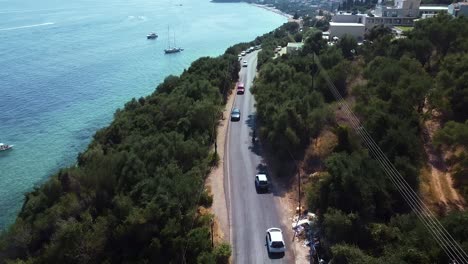 Aerial-following-shot-of-moving-motorbikes-and-cars-on-the-coastline-road