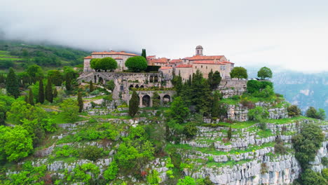 Beautiful-historic-houses-and-architecture-on-mountaintop-in-France-during-cloudy-day---Aerial-backwards-flight---Gourdon,France