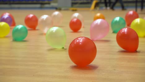 Bunte-Luftballons,-Die-Auf-Dem-Holzboden-In-Einem-Partyort-Für-Eine-Veranstaltungsfeier-Verstreut-Sind