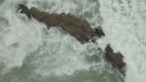 Aerial-ascending-top-shot-of-waves-crashing-rocks