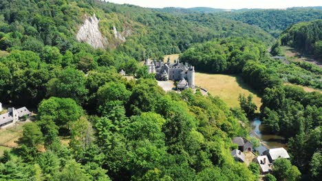 Renoviertes-Schloss-Inmitten-Dichter-Wälder,-Neben-Einem-Fluss