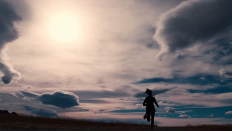 Beautiful-black-silhouette-outline-of-a-female-jogger,-jogging-against-a-dramatic-sky