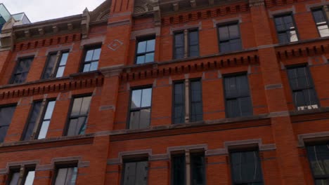 A-beautiful-smooth-driving-shot-of-a-red-brick-building-in-a-downtown-area