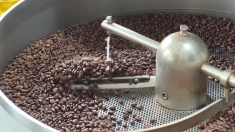 Aromatic-coffee-beans-roasting-and-cooling-down-on-the-plate-of-the-machine,-commodity-price-increase,-supply-chain-inflation-concept
