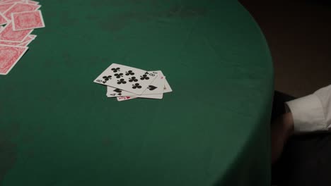 Ein-Besiegter-Spieler-Wirft-Seine-Verlorene-Hand-In-Einem-Dunklen,-Stimmungsvollen-Casino-Hin