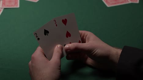 Spieler-Zieht-Zwei-Karten-Und-Legt-Sie-Zurück-In-Ein-Dunkles,-Launisches-Casino