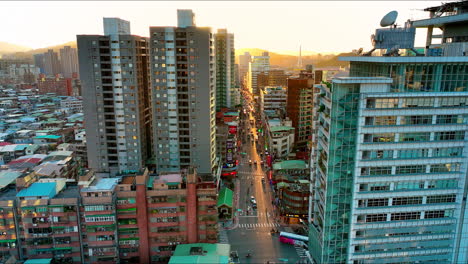 Aerial-of-several-apartment-block-complex-in-central-city-of-Taipi-with-traffic-on-road-and-bright-sunset-at-horizon---Beautiful-cityscape-of-asian-city
