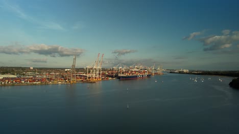 Aufsteigender-Flug-über-Den-Test-River-Mit-Blick-Auf-Das-Containerterminal-In-Der-Ferne-In-Southampton,-England,-Großbritannien