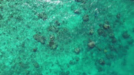A-drone-is-looking-down-on-clear-turquoise-water-flowing-over-rocks