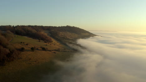 Insane-drone-aerial-footage-of-beautiful-cloud-inversion-and-low-clouds-on-a-hill-in-the-English-countryside-at-sunrise