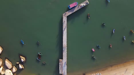 Sea-Pier-and-Small-Boats-Anchored-near-the-Beach,-Aerial-Top-Down