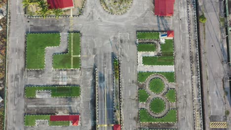 Vertical-top-down-aerial-view,-drone-flyover-driving-training-course-at-perak-malaysia-with-palm-trees