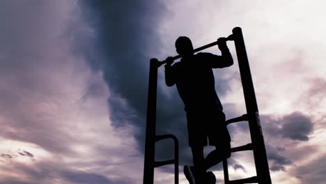 Powerful-black-silhouette-outline-of-a-male-doing-pull-ups-or-chin-ups-against-a-dramatic-sky
