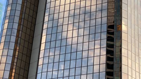 Corporate-buildings-exterior-with-reflective-glass-windows-reflecting-beautiful-sky-and-clouds-at-downtown-metropolitan-area-of-Brisbane-city,-Queensland,-QLD,-close-up-static-shot