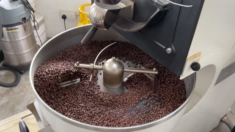 Coffee-beans-roasting-and-cooling-down-on-the-plate-of-the-machine,-commodity-price-increase,-supply-chain-inflation-concept