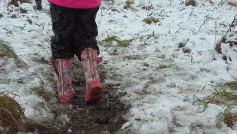 Slow-motion-child-walking-in-wellies-in-snow-field