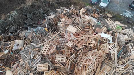 Aerial-flying-at-low-altitude-towards-and-across-huge-dumpsite-pile-filled-with-tons-of-wooden-and-bulky-waste-made-up-of-euro-pallets