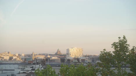 The-skyline-of-the-city-of-Brussels,-Belgium,-during-sunset,-with-the-Koekelberg-cathedral-in-the-distance-on-the-horizon