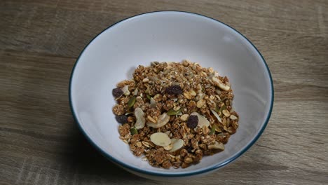 Zoom-out-of-the-Granola-in-a-bowl-with-seeds,-dried-fruits,-raisins,-perfect-healthy-breakfast