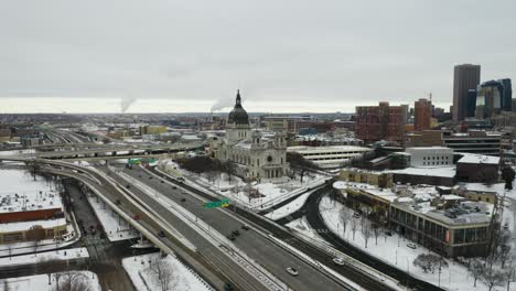 Birds-Eye-View-of-Basilica-of-Saint-Mary,-Minneapolis-Skyline-with-Traffic-Passing-Below