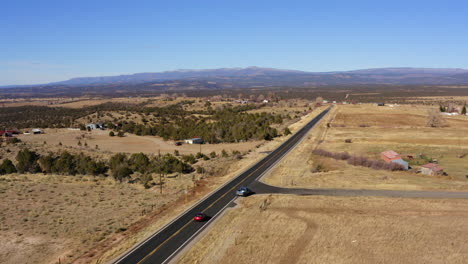 Aerial-top-view-of-two-cars-running-on-a-highway-in-Norwood,-Colorado