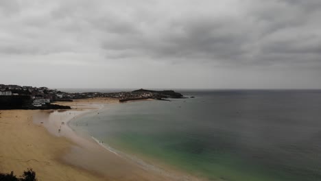 Rising-aerial-Drone-shot-looking-over-Porthminster-Beach-to-St-Ives,-Cornwall-England-UK