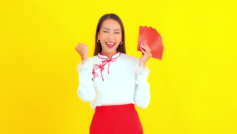 Happy,-Cheering-Woman-Holding-Blank-Red-Cards-in-Hand,-Yellow-Backdrop