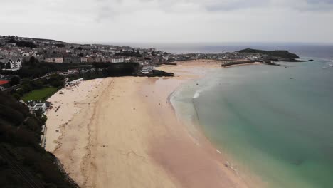 Aerial-lowering-pedestal-shot-of-Porthminster-Beach-and-St-Ives-Harbour-Cornwall,-England-UK