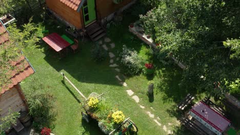 Old-Vintage-Wooden-House-Cottages-On-Idyllic-Rural-Countryside-Garden---aerial-drone-shot