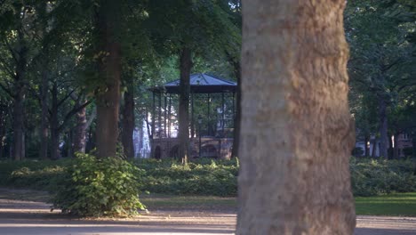 Schöner-Pavillon-In-Einem-Atemberaubenden-Park-In-Der-Stadt-Brüssel,-Belgien,-Im-Koekelberg-viertel,-Mit-Hohen-Grünen-Sommerbäumen-Und-Einer-Landschaft,-Die-Ihn-Umgibt,-Und-Häusern-Im-Fernen-Hintergrund