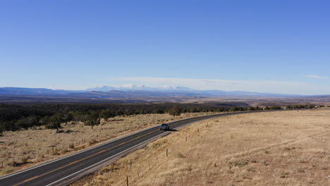Vista-Aérea-De-Dos-Autos-Conduciendo-Por-Una-Carretera-Rural-En-Norwood,-Colorado