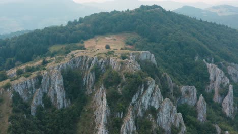 Aerial-view-of-mountain-peak-and-cliffs-on-misty-day