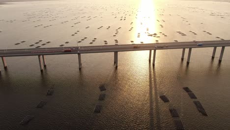 Verkehr-Auf-Der-Hong-Kong-shenzhen-Bay-Bridge-Bei-Sonnenuntergang,-Mit-Fisch--Und-Austernzuchtpools,-Luftbild