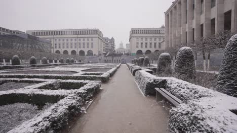 Steady-pov-shot-of-snowy-Jardin-de-Mont-des-Arts-during-snowfall-in-Brussels,-Belgium