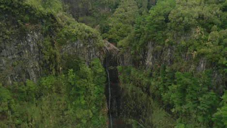 Fast-Ausgetrockneter-Wasserfall,-Umgeben-Von-Steilen-Klippen,-Die-Mit-üppigen-Pflanzen-Bedeckt-Sind