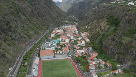 Aerial-of-scenic-town-in-volcanic-valley-in-Madeira,-secluded-between-cliffs