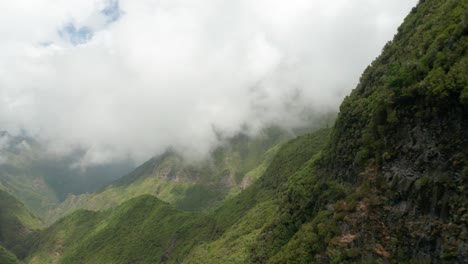 Majestuosas-Montañas-Verdes-Con-Nubes-Bajas-Que-Cubren-Picos,-Antena