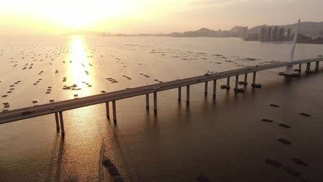 Traffic-on-Hong-Kong-Shenzhen-Bay-Bridge-at-Sunset,-with-Fish-and-Oyster-cultivation-pools,-Aerial-view