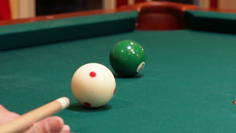 Closeup-of-Person-Playing-Pool-Shooting-Solid-Green-6-Ball-into-Corner-Pocket-after-Practice-Strokes-using-Cue-Ball-with-Red-Spots,-Open-Bridge-Hand-with-Wooden-Cue-Stick-and-Green-Felt-or-Cloth