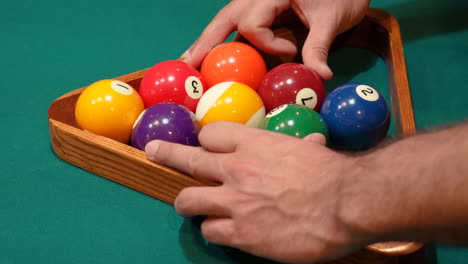 Man-Adjusts,-Messes-and-Fiddles-with-9-Ball-Pool-Diamond-Rack-and-Tightens-Balls-with-Hands-before-Lifting-Wooden-Triangle-on-the-Spot-Closeup-on-a-Table-with-Green-Felt-or-Cloth