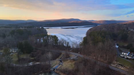 Aerial-drone-footage-of-lakes,-hills,-mountains,-and-forests-during-sunset-in-the-Appalachian-mountain-during-winter