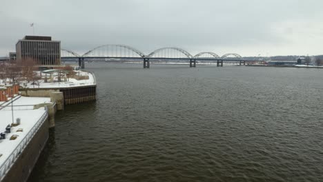 Drone-Flies-Toward-Centennial-Bridge-in-Winter,-Connecting-Illinois-and-Iowa-along-the-Mississippi-River