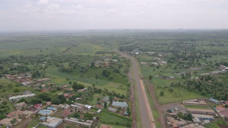 Landstraße-Zwischen-Grünen-Feldern-Und-Bäumen-In-Der-Ländlichen-Stadt-Loitokitok-In-Kenia---Drohnenaufnahme-Aus-Der-Luft