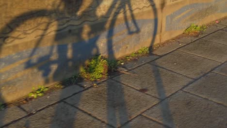 Slow-motion-shadow-of-cyclist-riding-bike-to-commute-to-work-during-sunrise-sunset