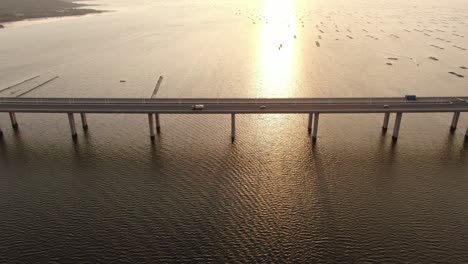 Traffic-on-Hong-Kong-Shenzhen-Bay-Bridge-at-Sunset,-with-Fish-and-Oyster-cultivation-pools,-Aerial-view