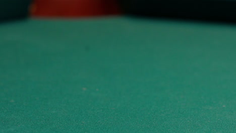 Closeup-of-Yellow-Striped-Nine-Ball-Being-Shot-into-the-Corner-Pocket-of-a-Brunswick-Pool-Table-by-Cue-Ball-with-Red-Spots-Rolling-Out-of-Frame,-Green-Felt-or-Cloth-and-No-Faces